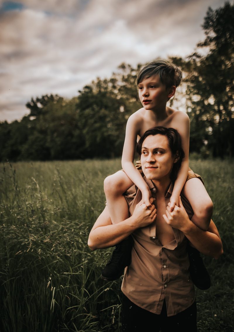 son sitting on fathers shoulders