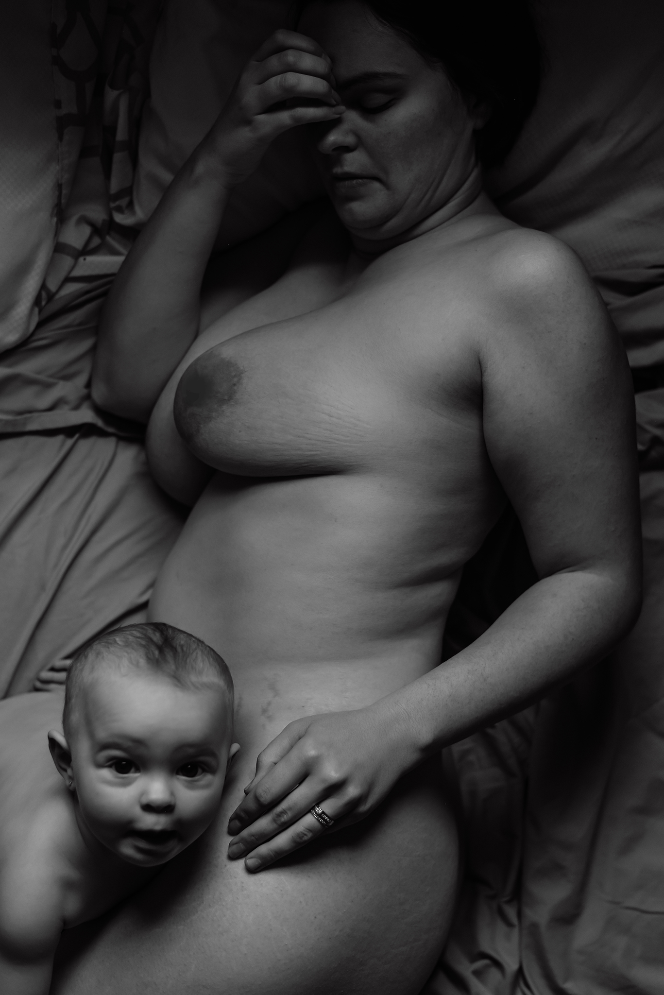 mother and baby breastfeeding in bed