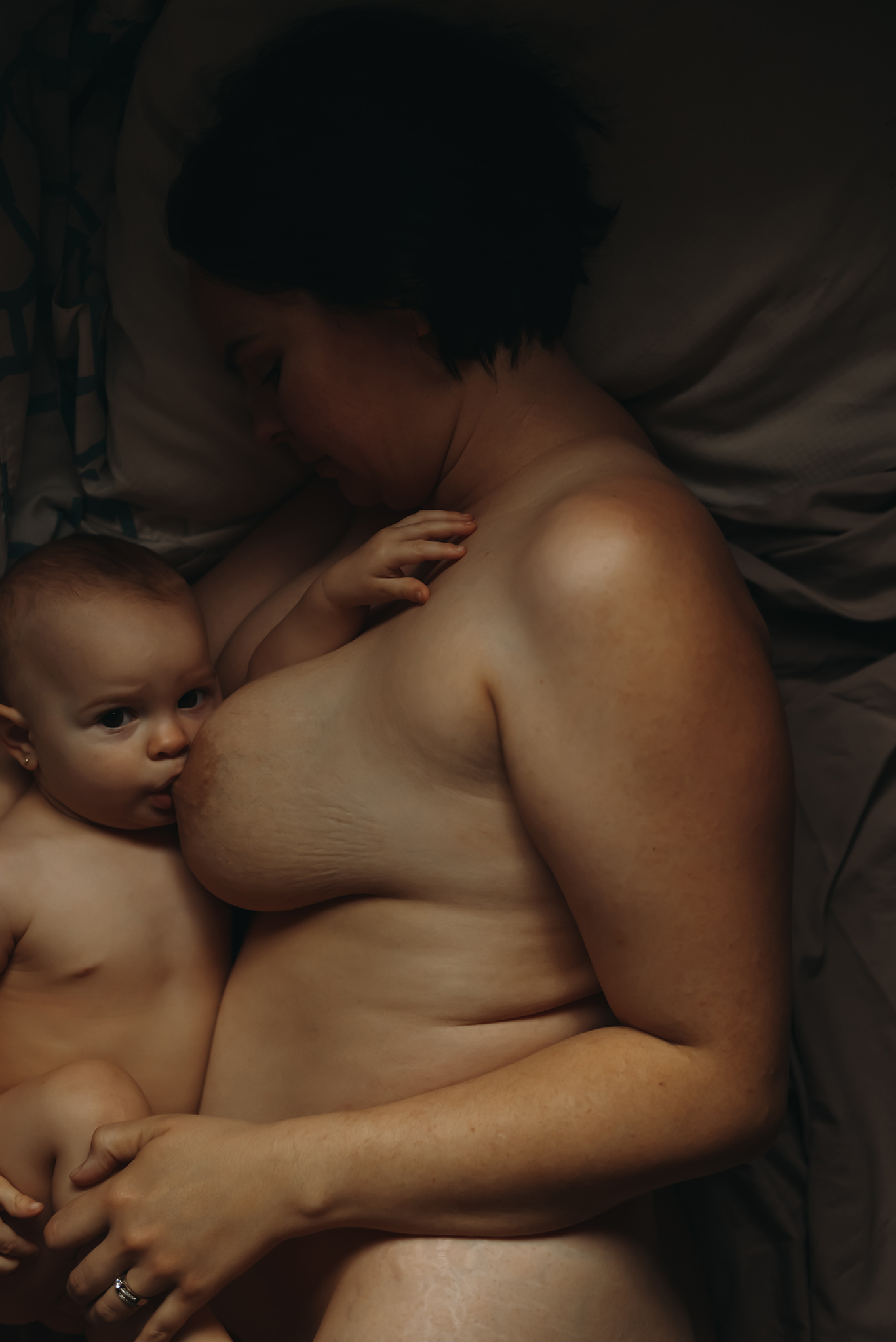 mother and baby breastfeeding in bed